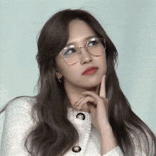 a close up of a woman wearing glasses and a white shirt .