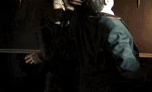 a man and a woman are fighting in a dark room