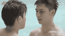 two shirtless men are looking at each other in a pool with a watermark that says ' good morning online ' on the bottom
