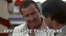 two men are talking to each other and one of them is holding another man 's neck .