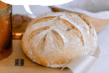 a loaf of bread is sitting on a table next to a container that says flour