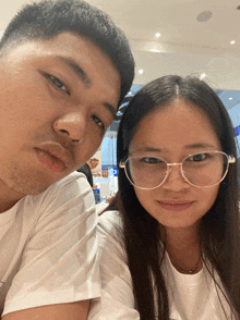 a man and a woman are posing for a picture and the man has a beard and the woman has glasses