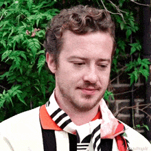 a man wearing a scarf around his neck has the name joe written on the bottom of the photo