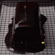 a loaf of chocolate cake on a cooling rack with the words mr cakes below it