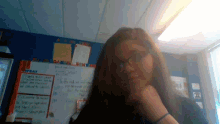 a girl stands in front of a white board that says what