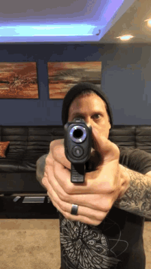 a man holds a gun in front of his face