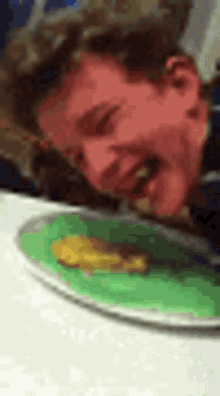 a man is sitting at a table with a plate of food .
