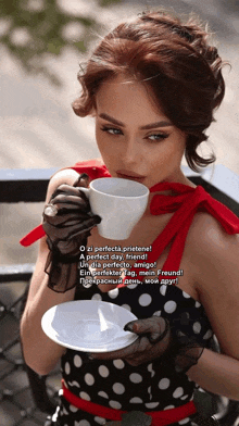 a woman in a polka dot dress is drinking from a white cup