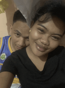 a man and a woman are posing for a picture and the man is wearing a jersey that says ' rc '
