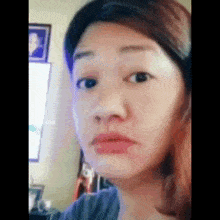 a woman is making a funny face while taking a selfie in a room .
