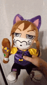 a person is holding a stuffed animal that is wearing a mask and holding a baseball bat .