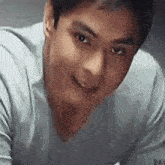a close up of a man 's face wearing a grey shirt .