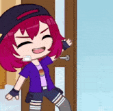 a girl with red hair is standing in front of a door and smiling
