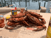 a container of old bay seasoning sits on a table with crabs