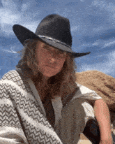 a woman wearing a cowboy hat and a white poncho