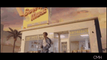 a man is standing in front of a store called sweet music records & cd