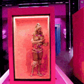a woman is standing in a pink box with a star in the corner