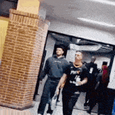 a man wearing a phx jersey walks through a hallway