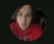 a blurry picture of a woman 's face in a red scarf in a circle .
