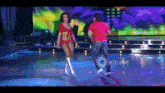 a man and a woman are dancing on a stage with eltrece written on the bottom of the screen