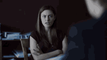 a woman with her arms crossed is sitting in a chair