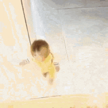 a baby is walking down a set of stairs in a room .