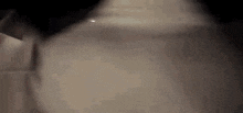 a close up of a person 's face in a dark room with a blurred background .