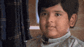 a close up of a young boy 's face looking at the camera .
