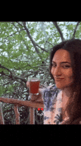 a woman sitting on a balcony holding a glass of juice