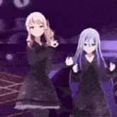 two anime girls are dancing on a stage in a dark room .