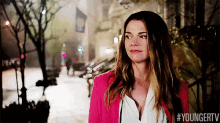 a woman in a pink jacket is walking down a street with the hashtag #youngertv