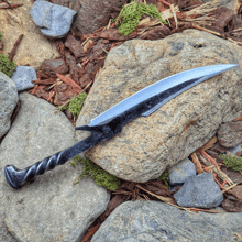 a knife with a twisted handle is sitting on a rock