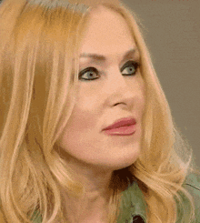a close up of a woman 's face with long blonde hair