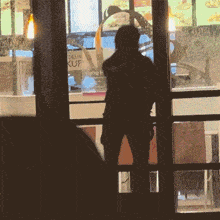 a man stands in front of a window with a sign that says delivery ruf on it