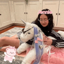 a girl holding a stuffed unicorn with the name jennie written on the top