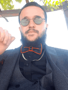 a man wearing glasses and a bow tie looks down