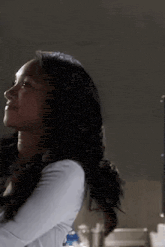 a woman with long hair is standing in front of a mirror in a bathroom .