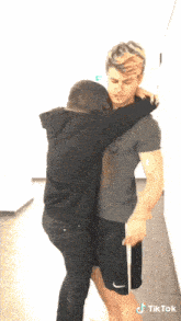 a woman is hugging a man with a tiktok watermark