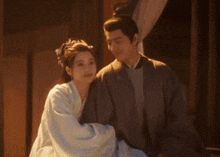a man and a woman standing next to each other in a room
