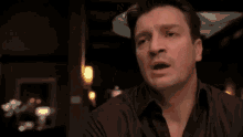 a man in a black shirt is pointing at something with his finger