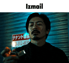 a man with a beard stands in front of a sign that says ' izmail '