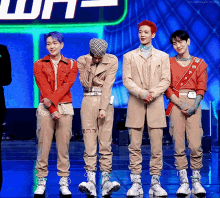 a group of men are standing next to each other in front of a neon sign that says why