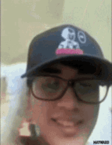 a man wearing glasses and a hat with a snoopy logo on it