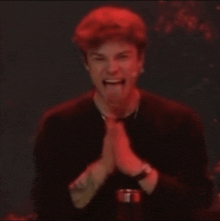 a man in a black shirt is making a funny face