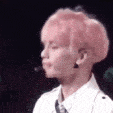 a close up of a person 's face with pink hair and a white shirt and tie .