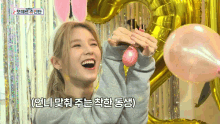 a woman is holding a pink balloon in front of a heart shaped balloon and a sign that says ' o '