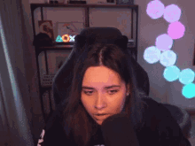 a woman is sitting in a chair in front of a sign that says box on it