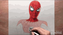 a person is drawing a picture of a spiderman on a piece of paper ..