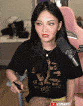 a woman sitting in front of a microphone wearing a black shirt that says san francisco