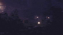 a dark night scene with a few lights in the distance